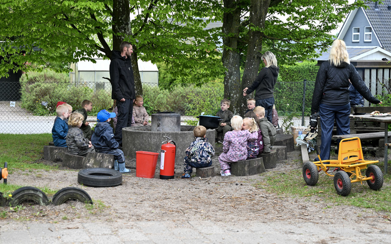 Børn og voksne laver bål