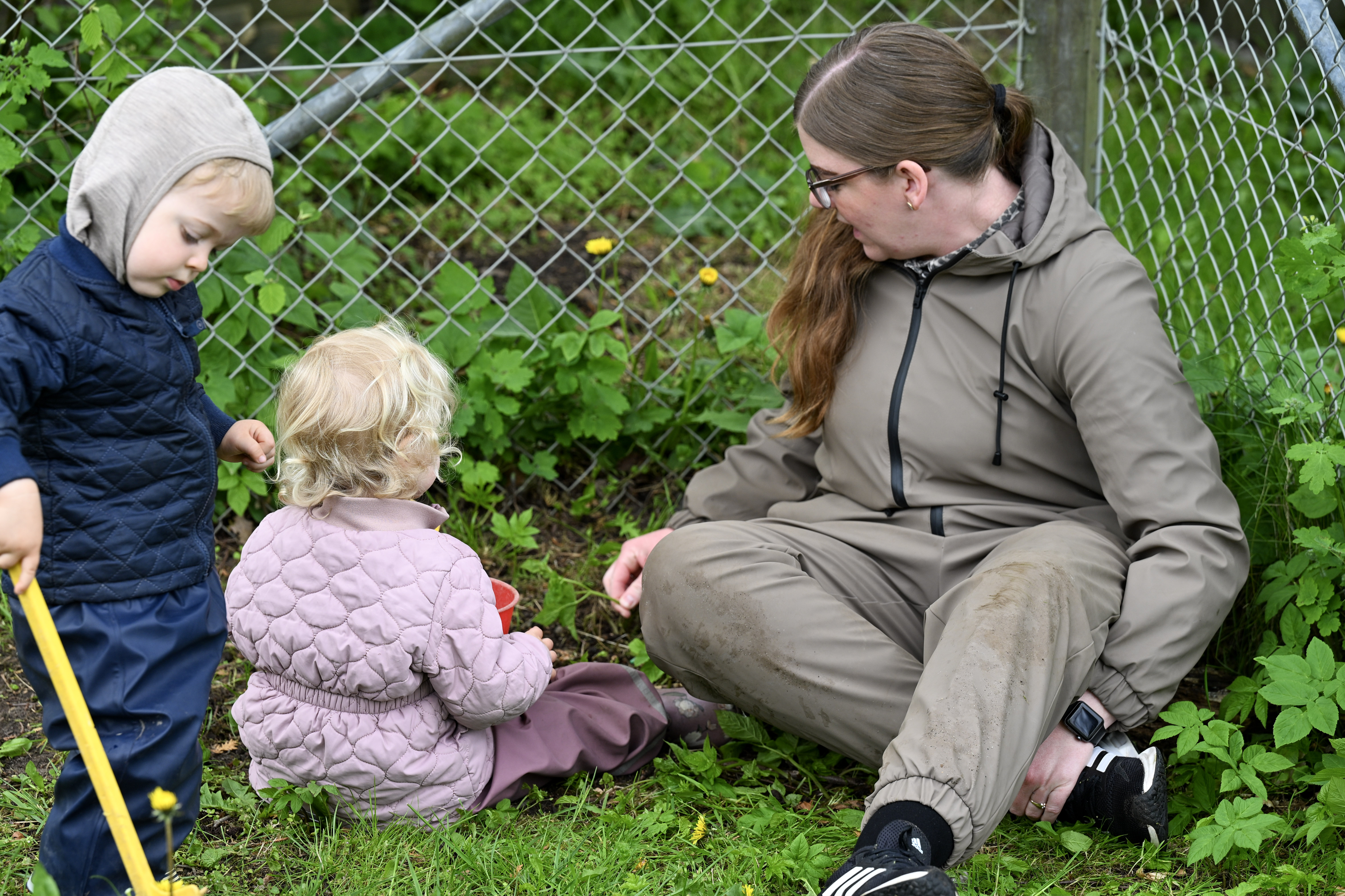 Børn og voksen kigger på planter
